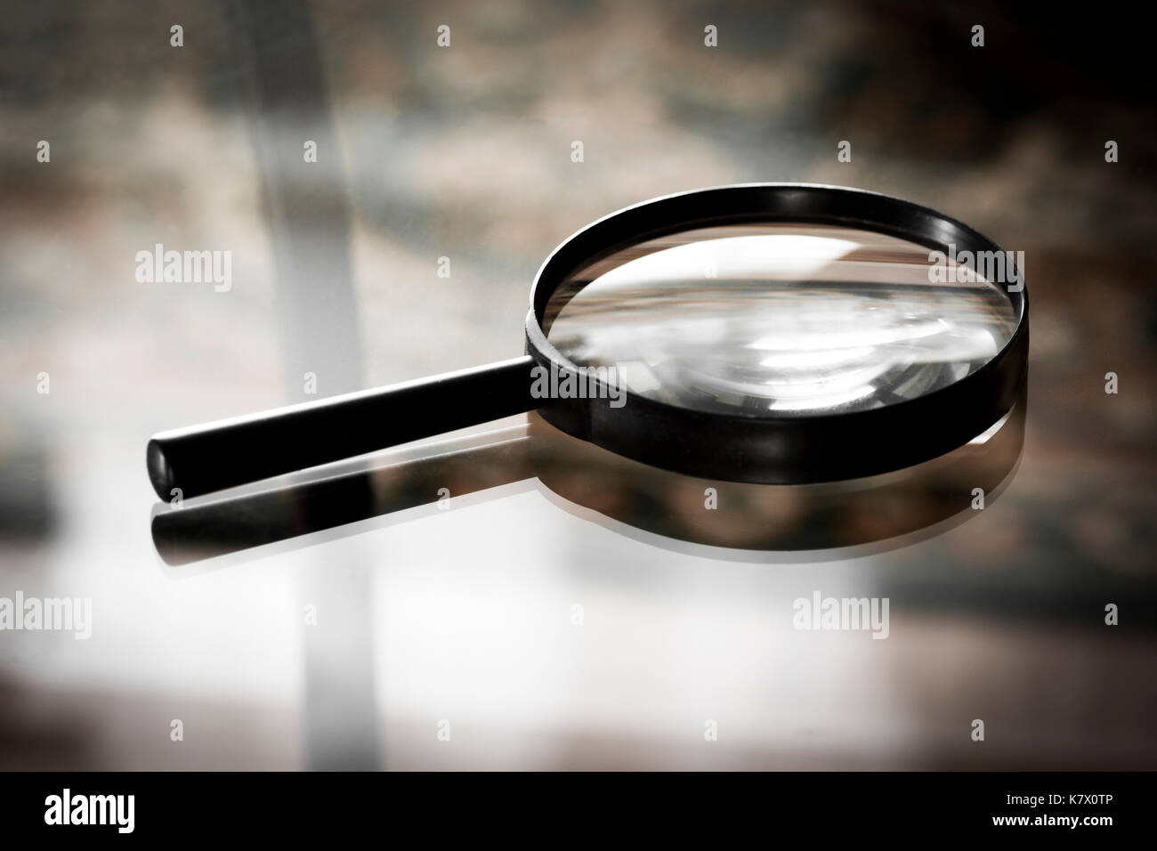 Loupe close-up on the surface of a glass table Stock Photo - Alamy