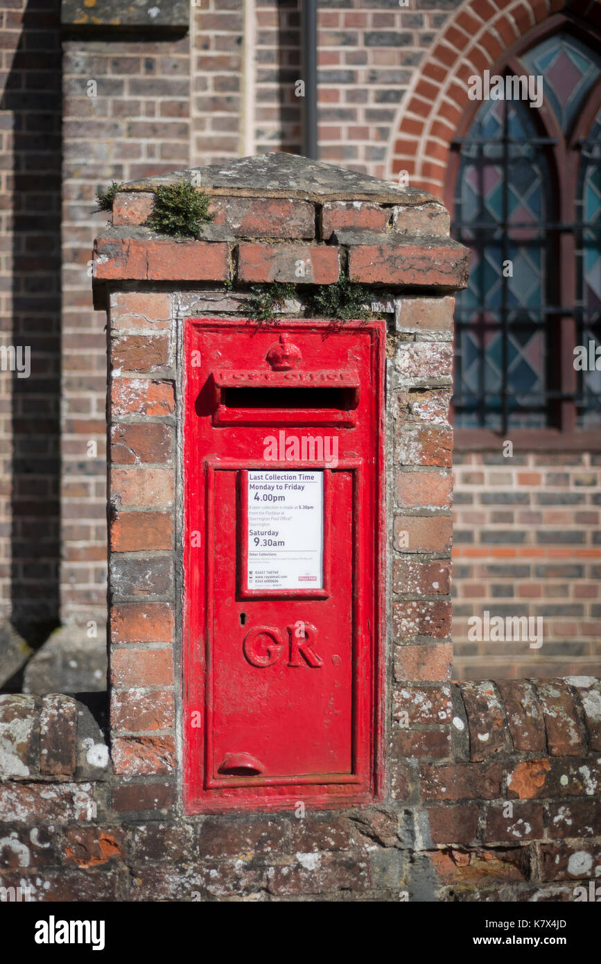Red Postbox in Wall of building, West Sussex, England Stock Photo