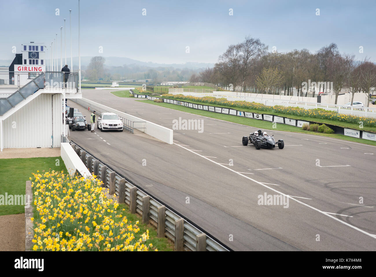 Fast car on racetrack at Goodwood with spectators Stock Photo