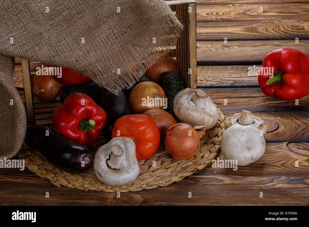 Fresh vegetables in overturned wooden box with burlap over wooden ...