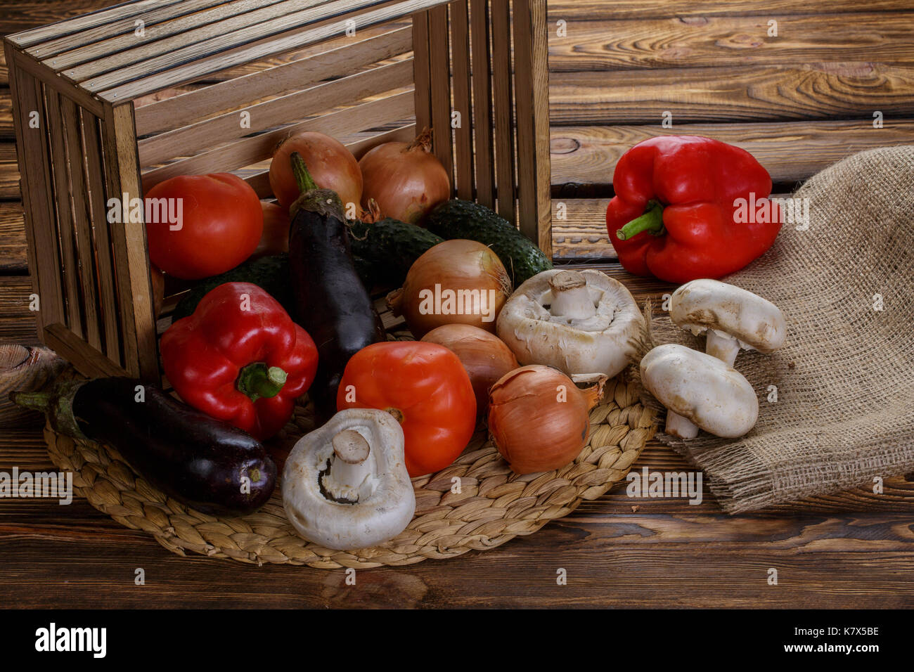 Fresh vegetables in overturned wooden box with burlap over wooden ...