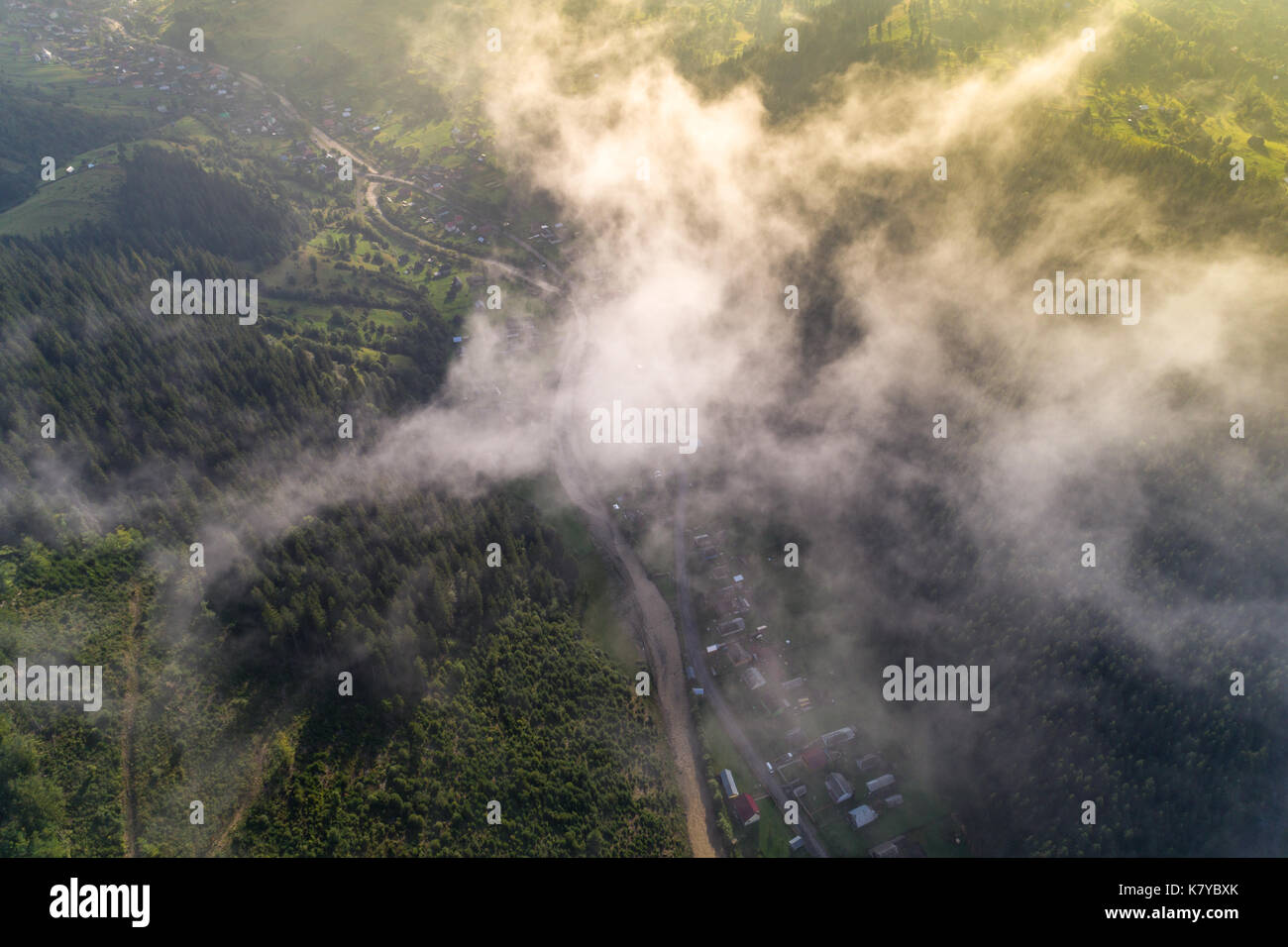 Aerial view of the village in the Carpathian mountains with clouds in ...