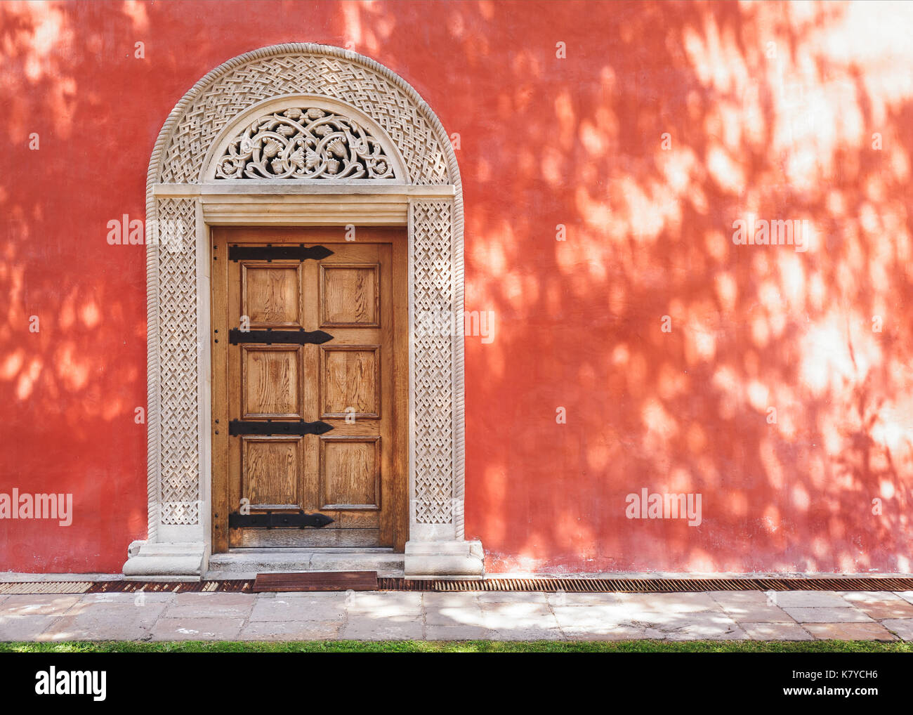 Zica monastery, 13th century, carved medieval stone door in the red stucco wall, architecture detail Stock Photo