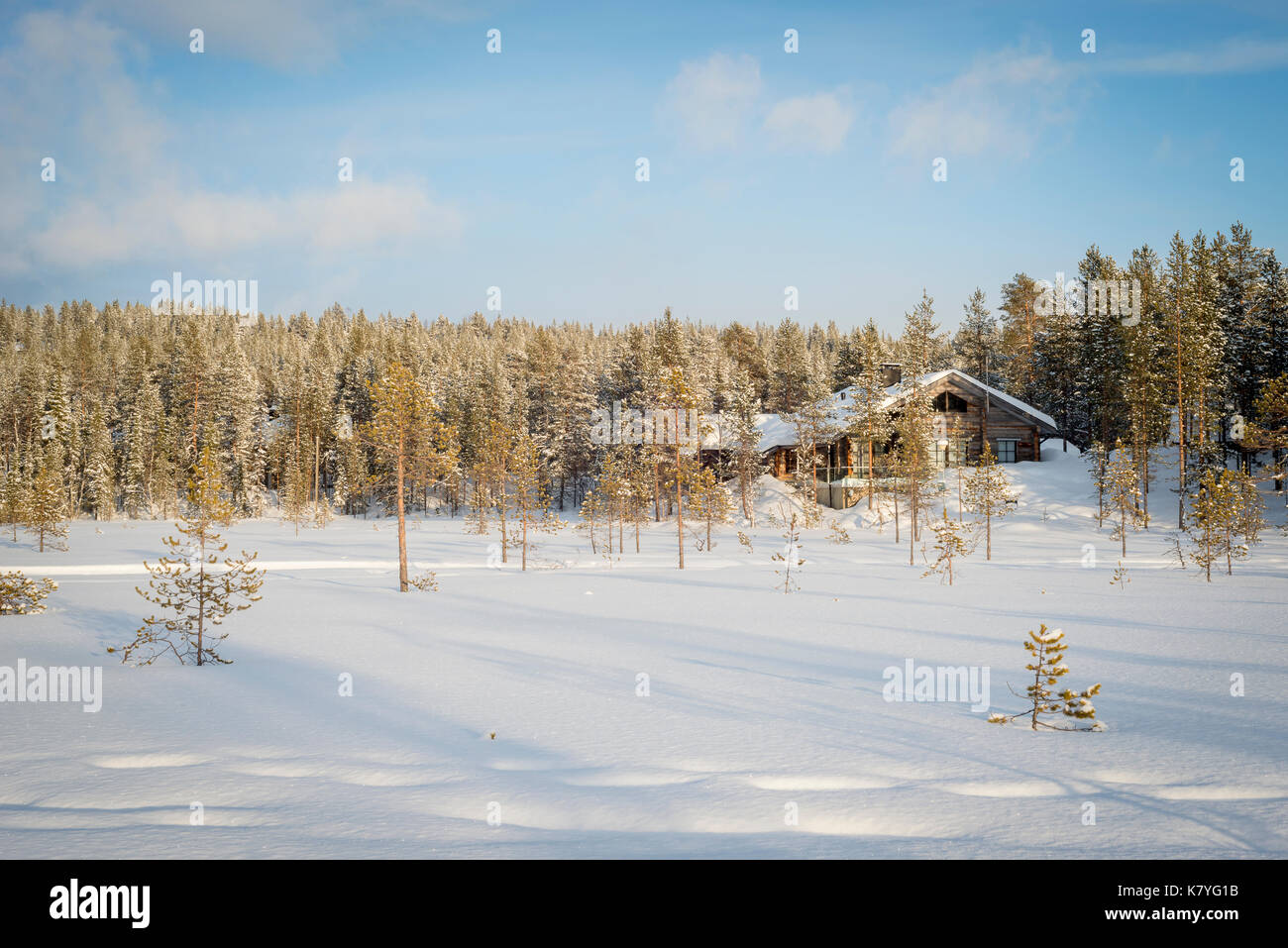 Wood cabin at edge of winter forest, Finland. Stock Photo