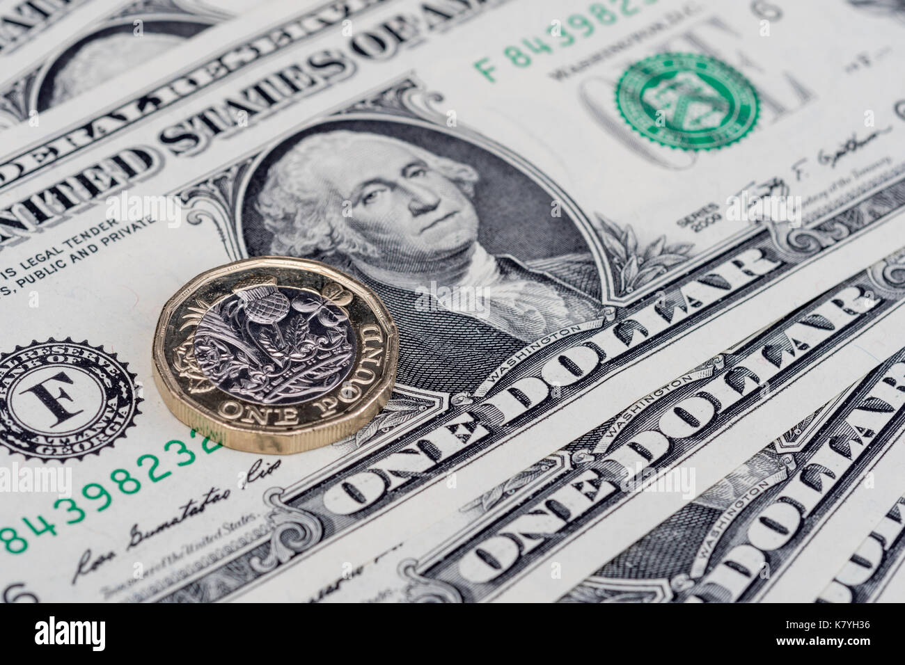 US dollar bills with a new, 12 sides,  British / UK pound coin. One dollar note USA. Stock Photo