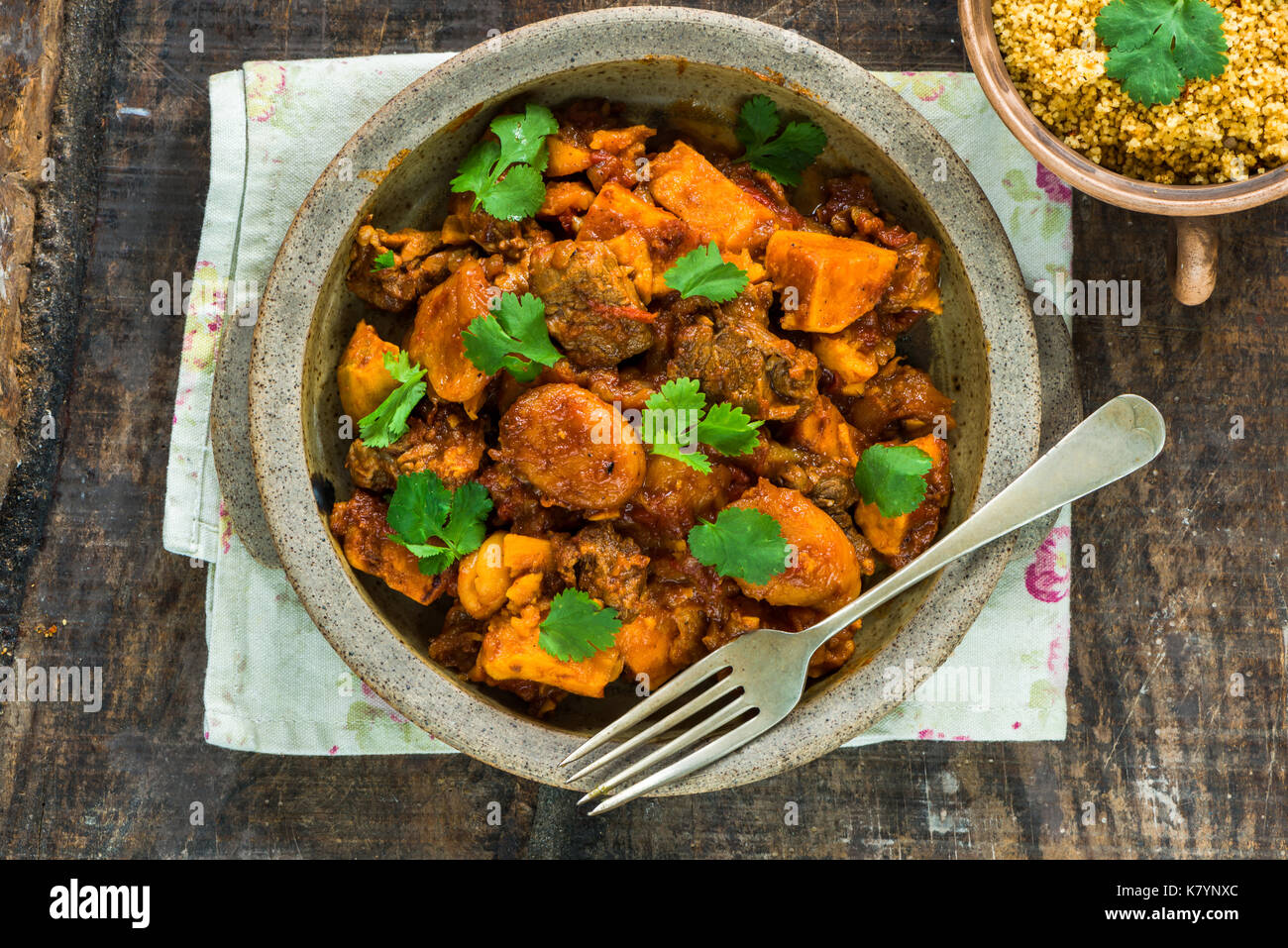 Maroccan lamb tajine with couscous garnished with fresh coriander leaves - high angle view Stock Photo