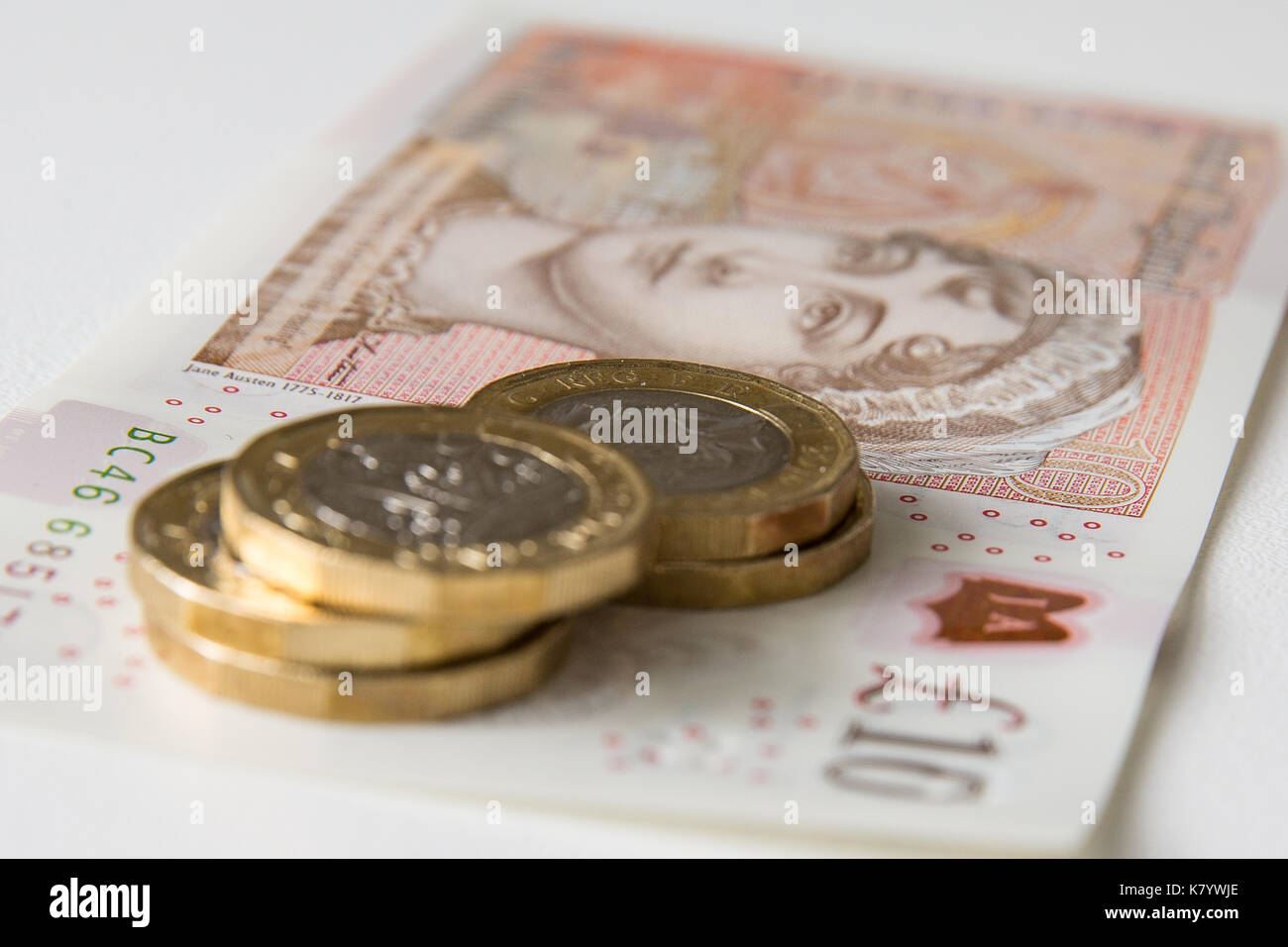 Image of the new, plastic, ten pound, sterling, note with five one pound sterling coins on top of it. Stock Photo