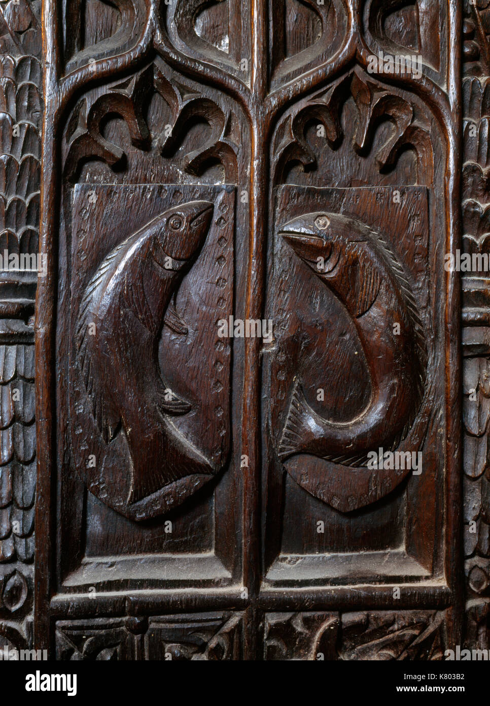 St Levan church, Cornwall: C15th bench end at W end of nave carved with two chad or young sea bream referring to a legend of C6th Celtic St Selevan. Stock Photo