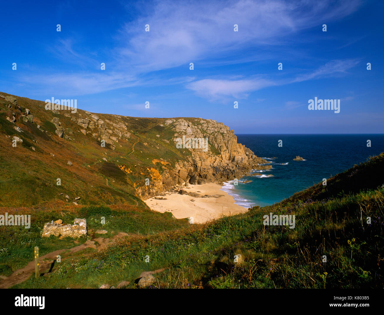 View SE of St Levan's well & baptistery above Porth Chapel Cove, West Penwith, Cornwall. Signpost (foreground L) indicates South West Coast Path et al Stock Photo