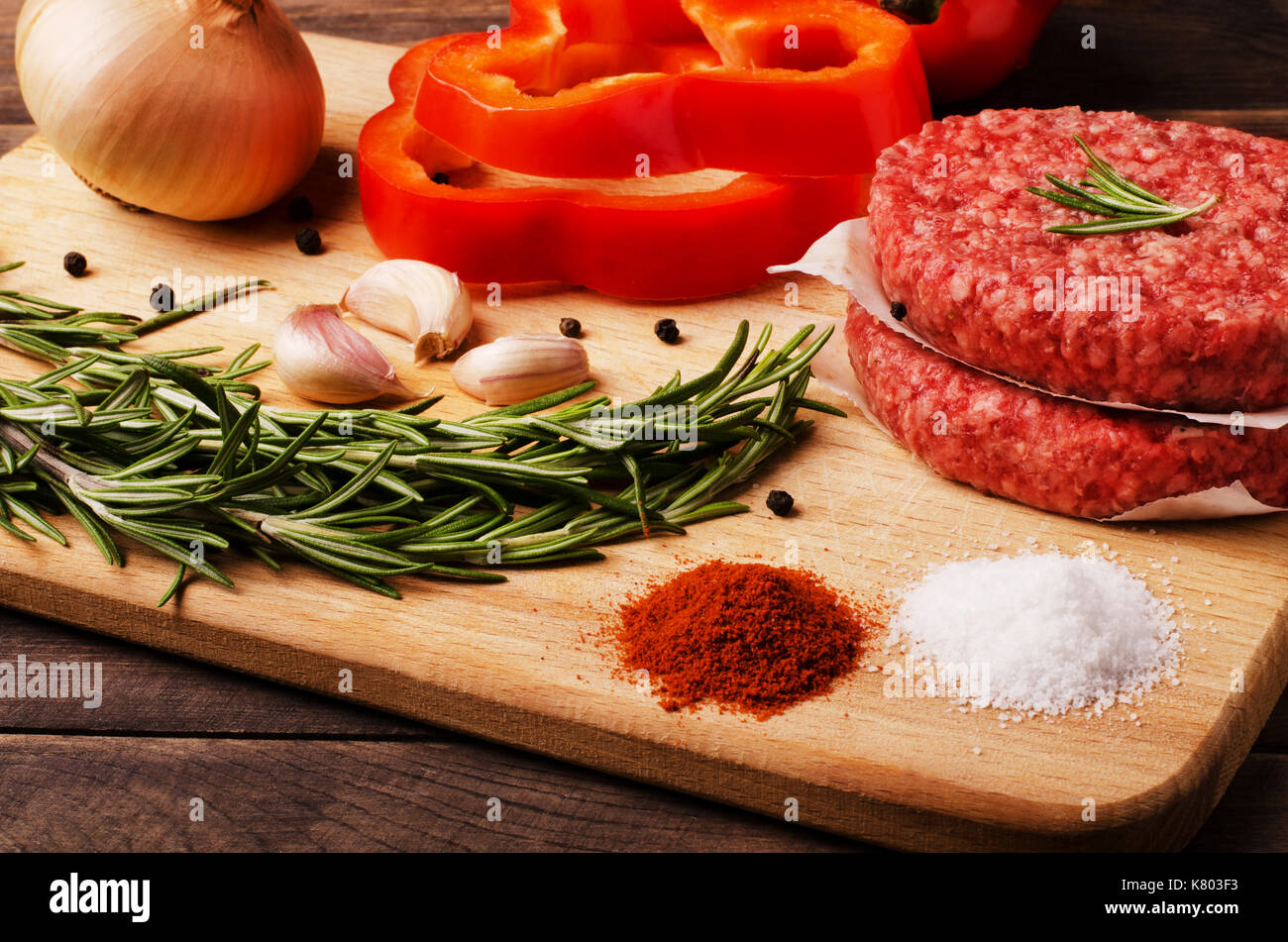 Raw ground beef burgers cutlets with red onion, garlic, olive and red