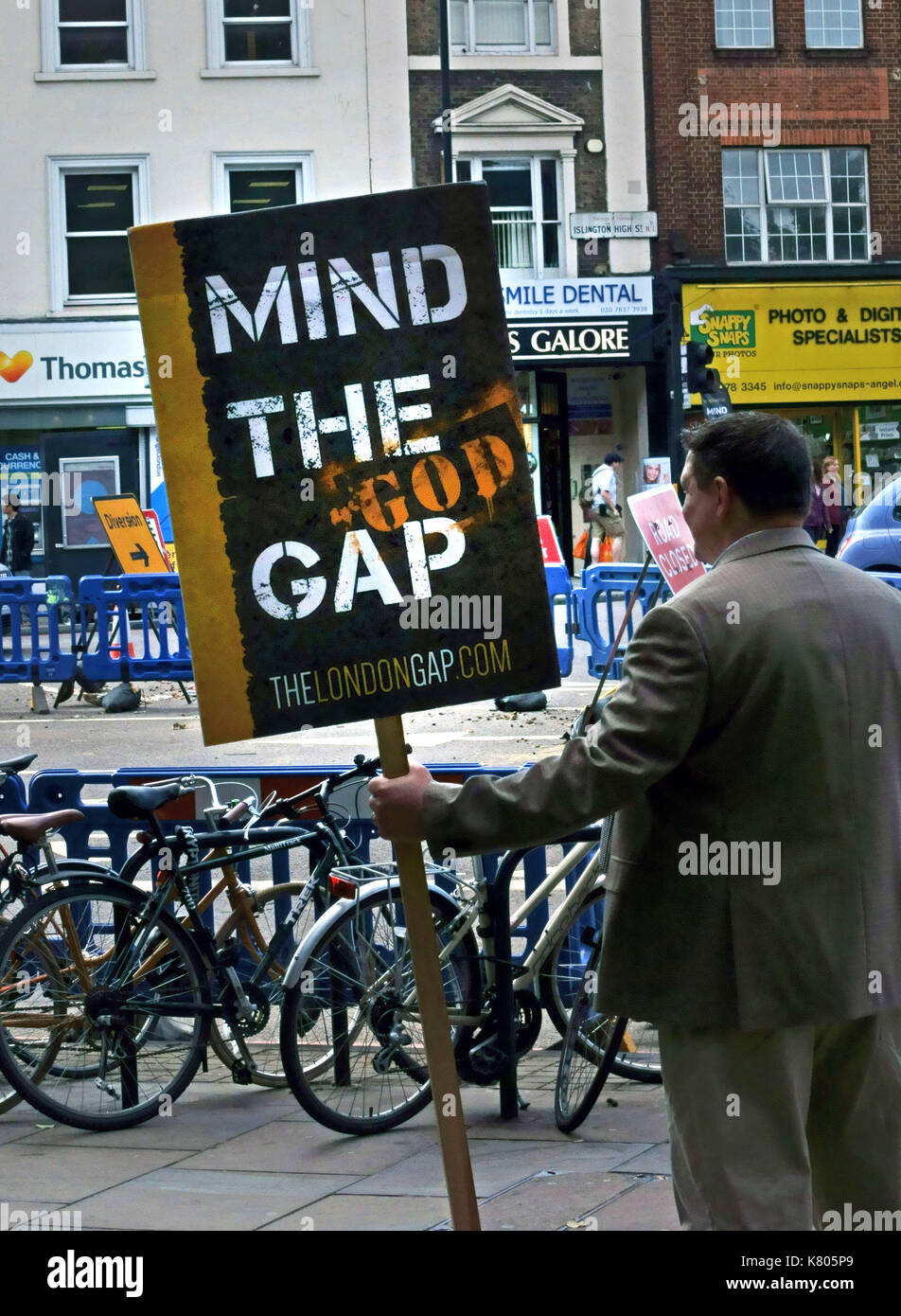 Evangelist in London high street with 'Mind the God Gap' sign Stock Photo