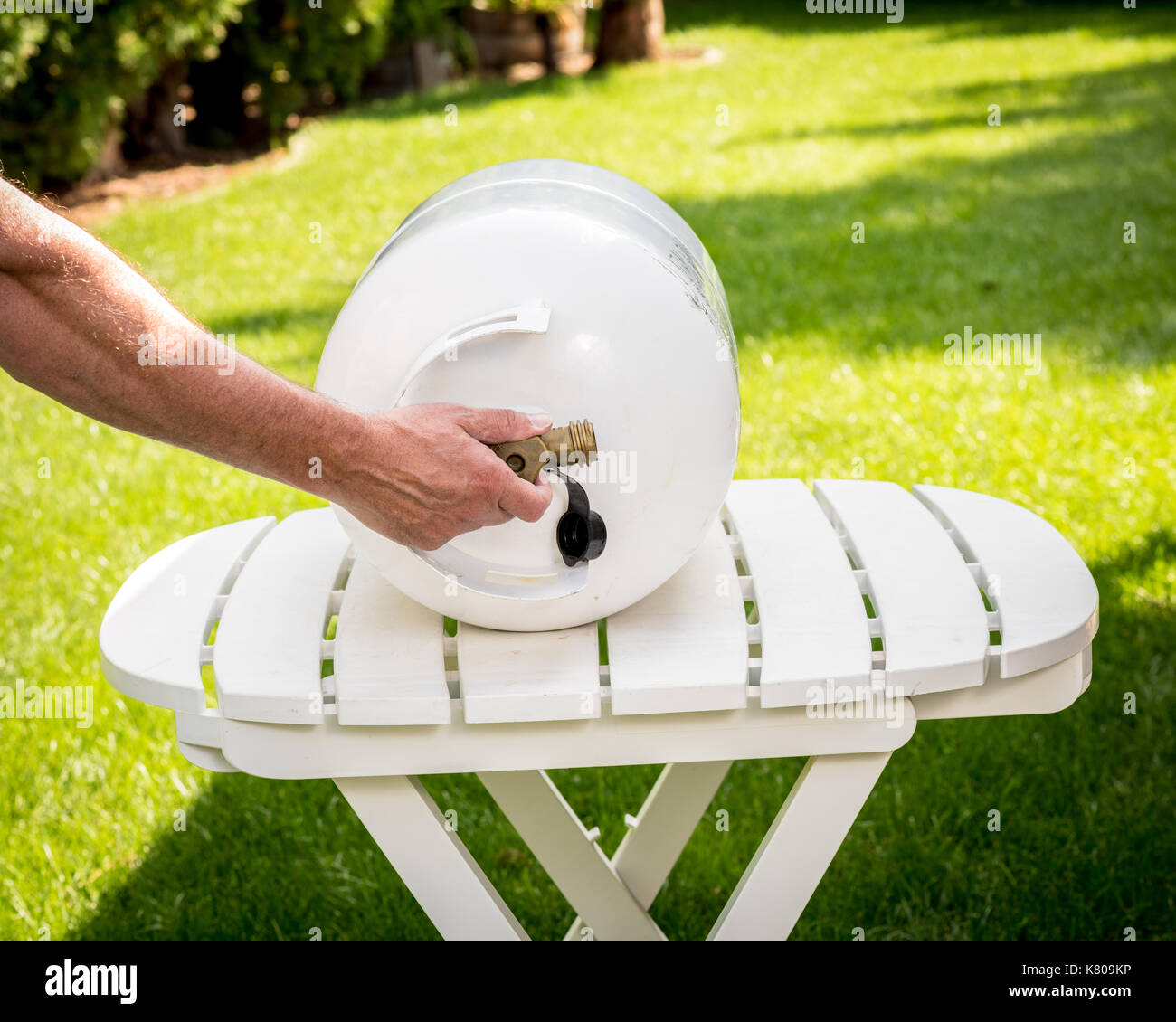 White propane tank with a brass knob in a backyard Stock Photo Alamy