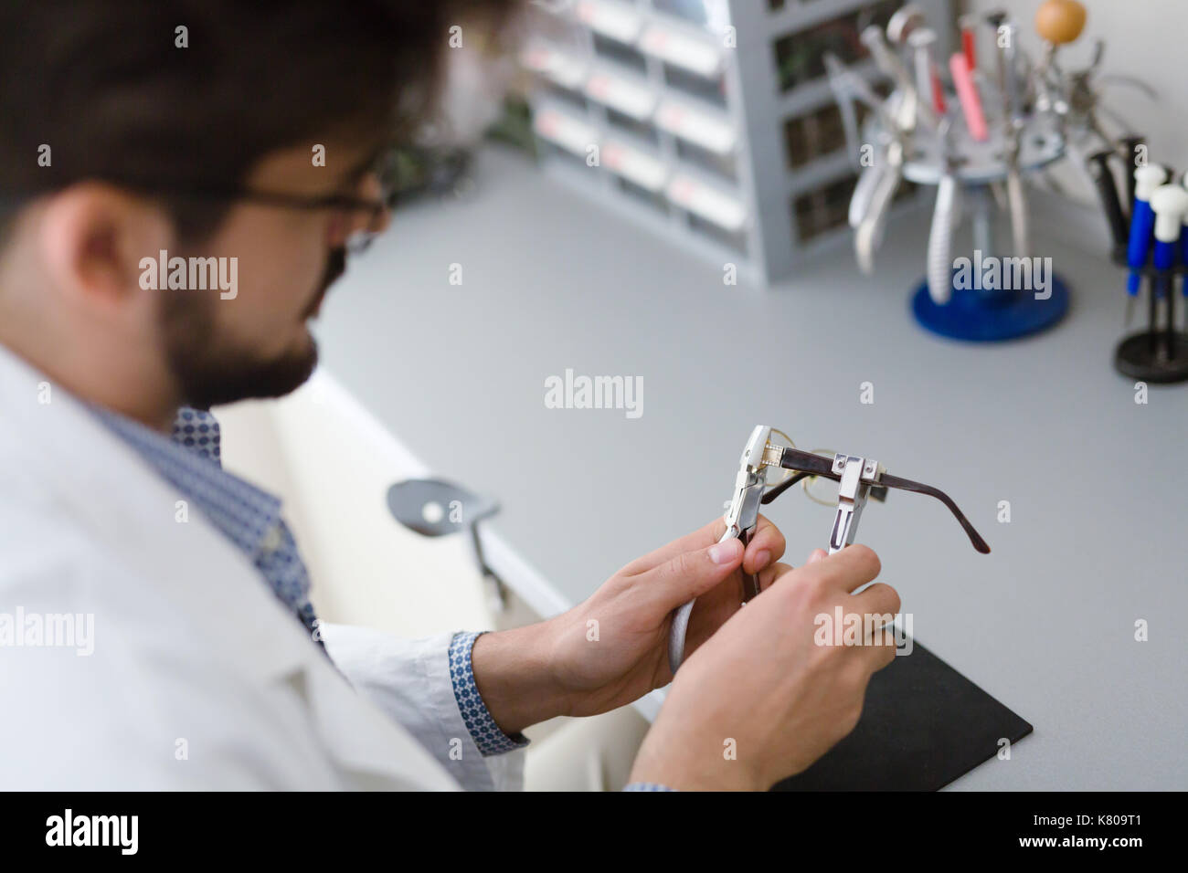 Optician repairing and fixing eye glasses Stock Photo