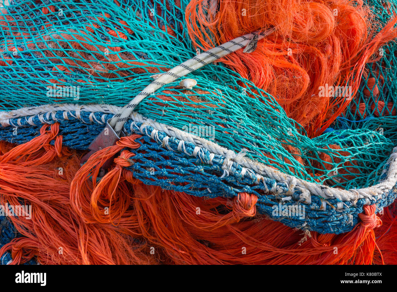 Fishing net. Close up of pile of fishing nets in harbor. Background of colorful fishing net. Barfleur, Normandy, France. Stock Photo