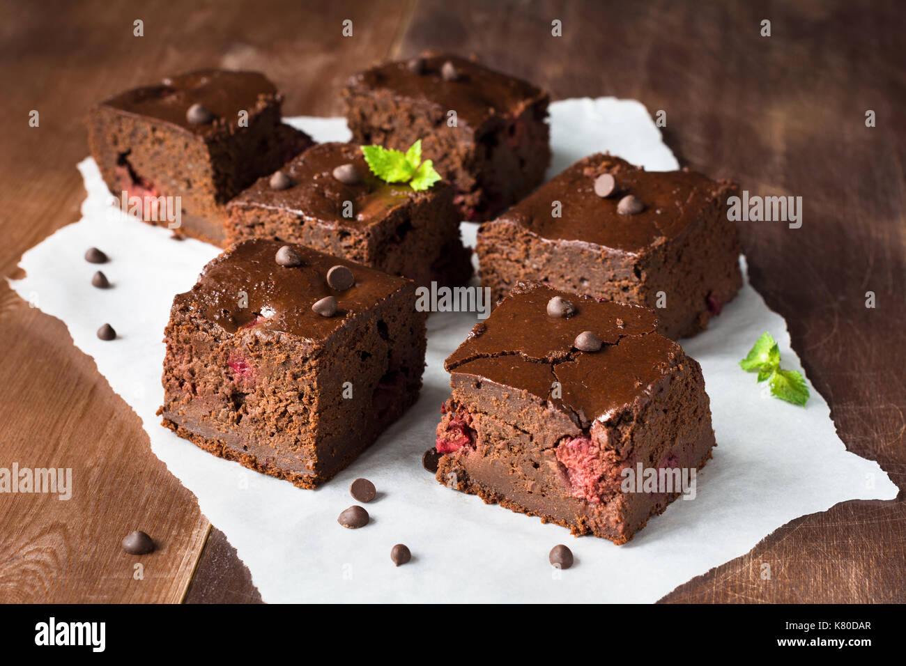 Dark Chocolate Brownies Decorated With Mint Leaf On Wooden Table