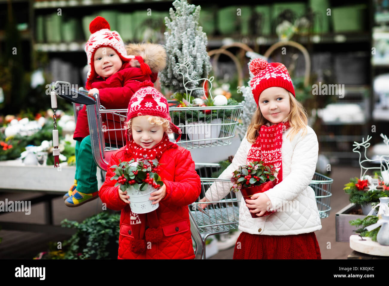 Family selecting Christmas tree. Kids choosing freshly cut Norway Xmas tree at outdoor lot. Children buying gifts at winter fair. Boy and girl shoppin Stock Photo