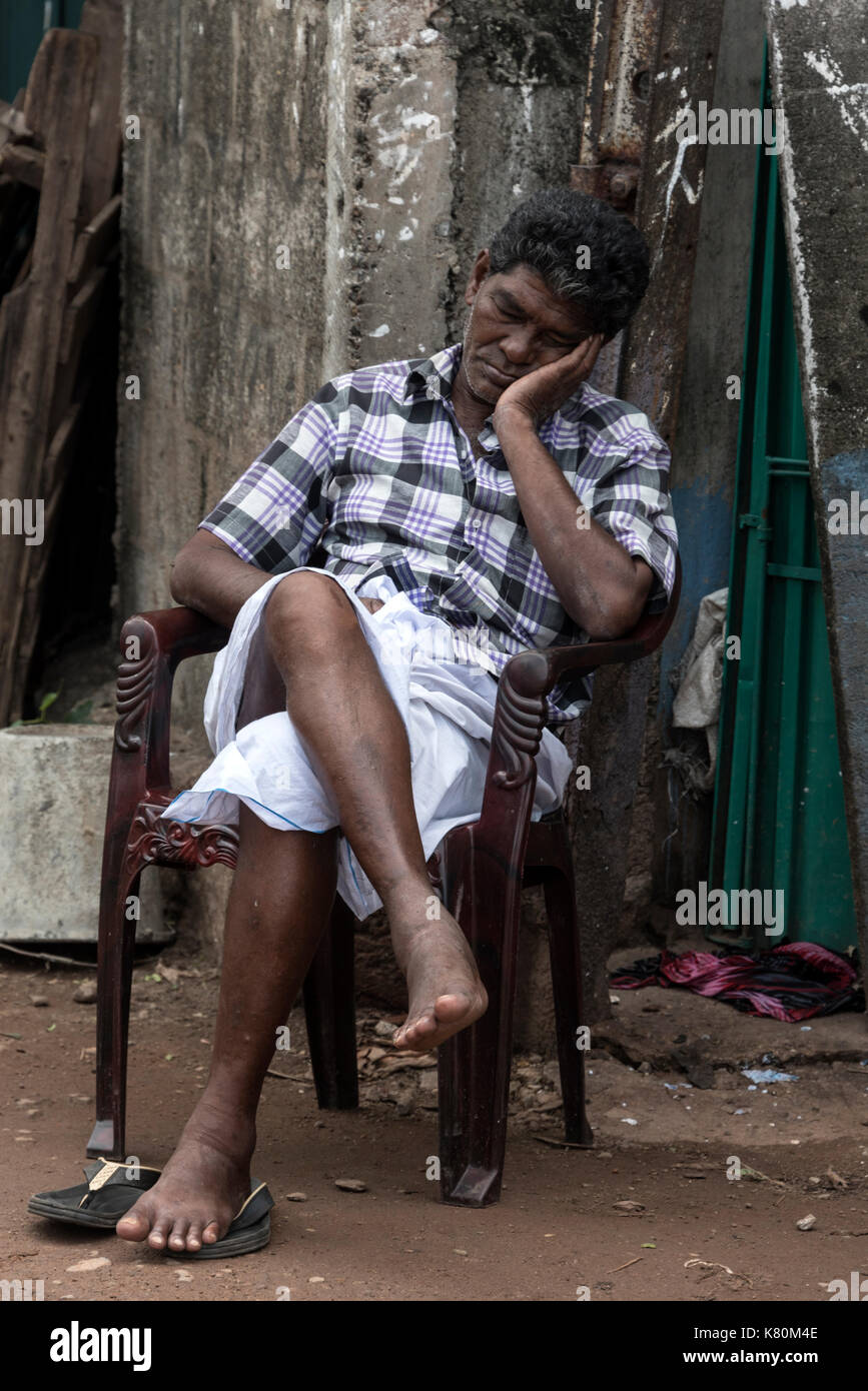 A sleeping car park attendant at a pay-in car park in Colombo, Sri Lanka Stock Photo