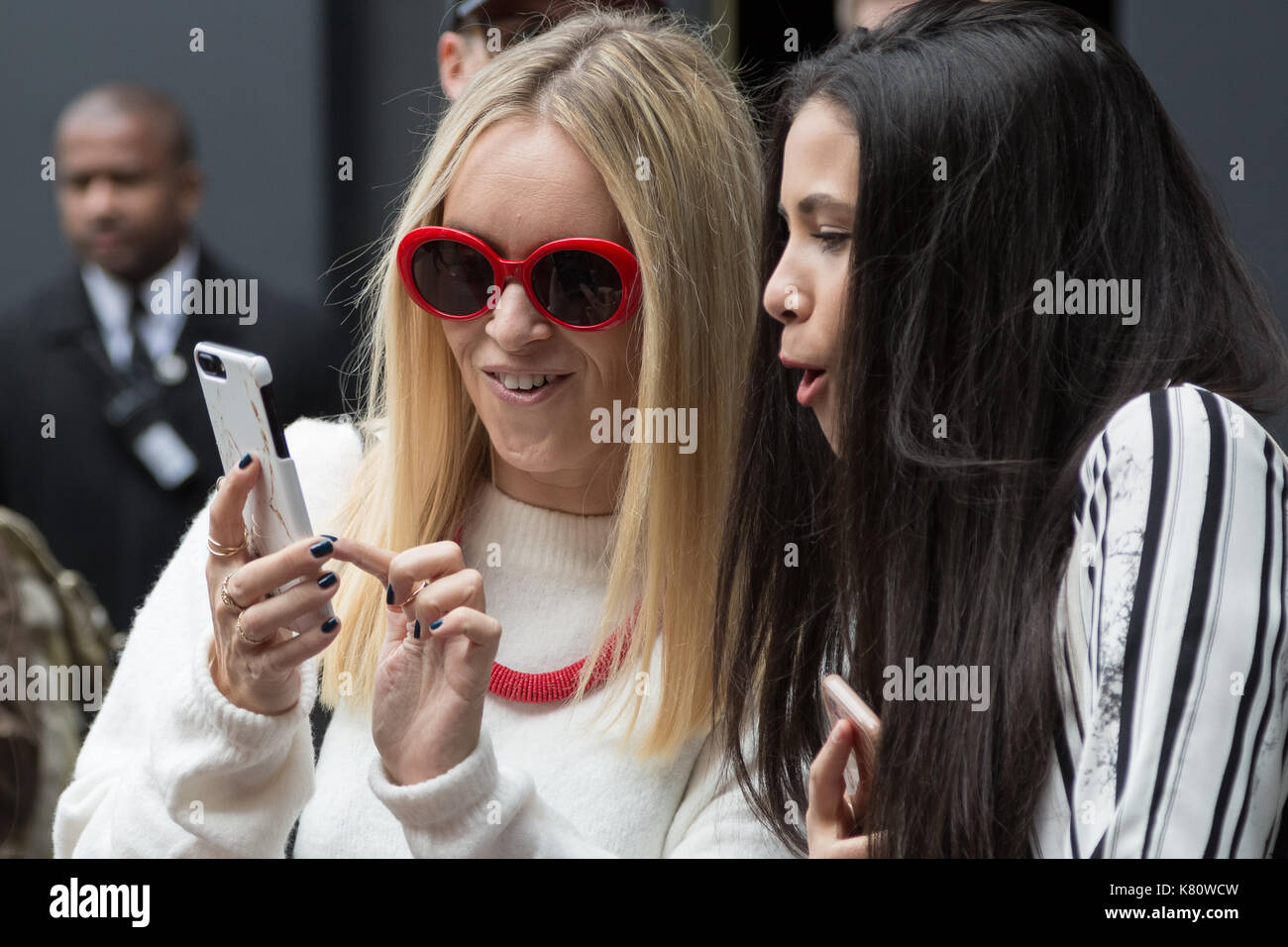 London, UK. 17th Sept, 2017. Two guests review phone pictures during London Fashion Week which sees guests, designers and fashion students arriving wearing personalised fashion creations for the various fashion shows and events. © Guy Corbishley/Alamy Live News Stock Photo