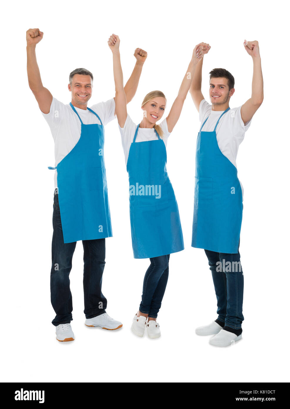 Team Of Happy Cleaners Raising Hands Over White Background Stock Photo