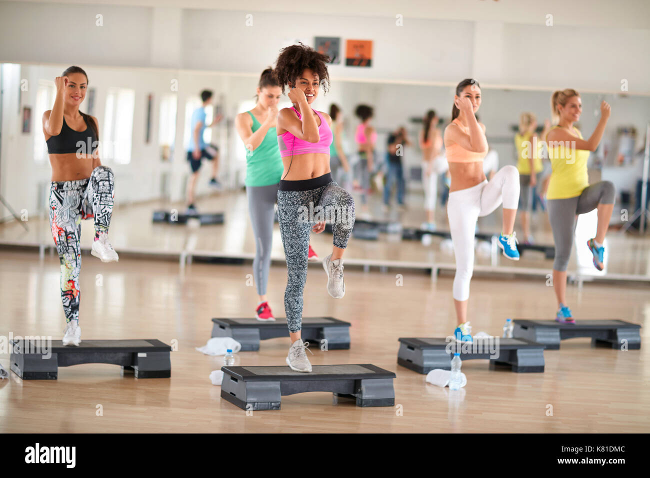Fitness group training on stepper in colorful sportswear Stock Photo