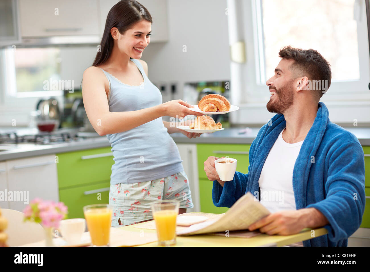 Young wife serving breakfast to husband Stock Photo