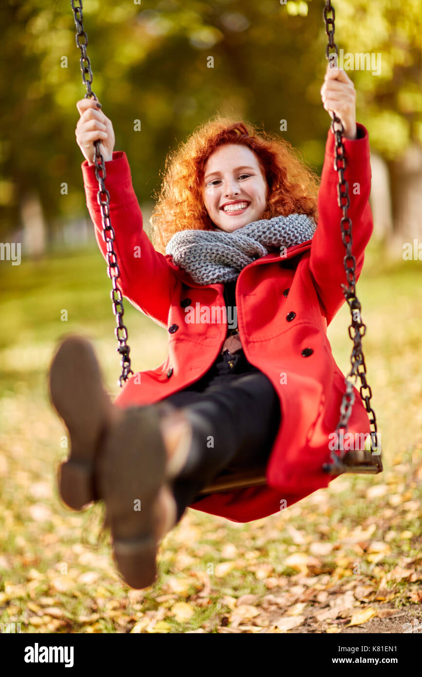 Happy curly ginger girl on swing in park Stock Photo Alamy