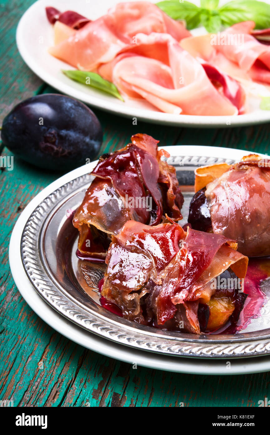 spicy spanish dish jamon with plum on a retro background Stock Photo