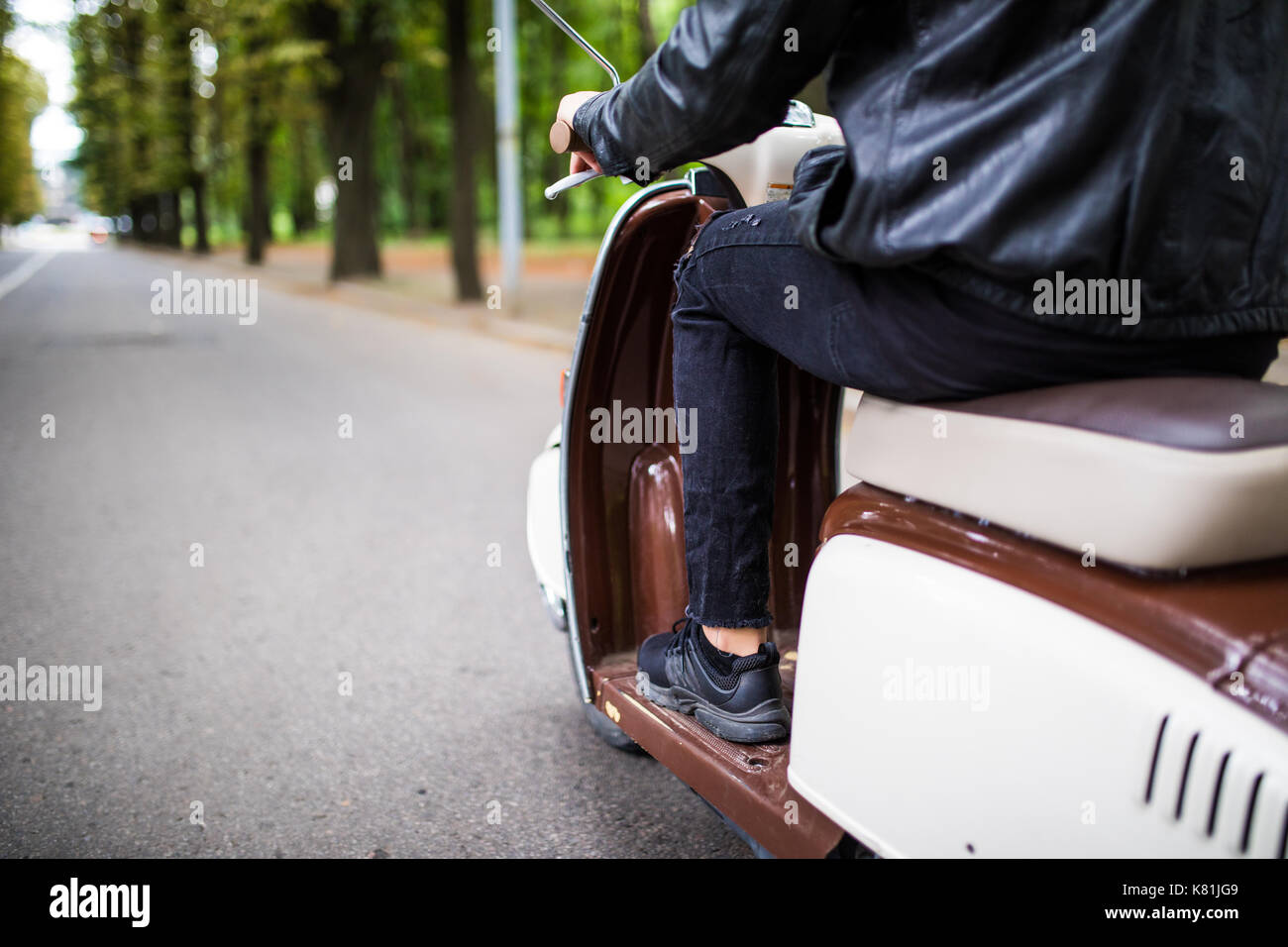 Close up portrait of young man driving scooter on street Stock Photo