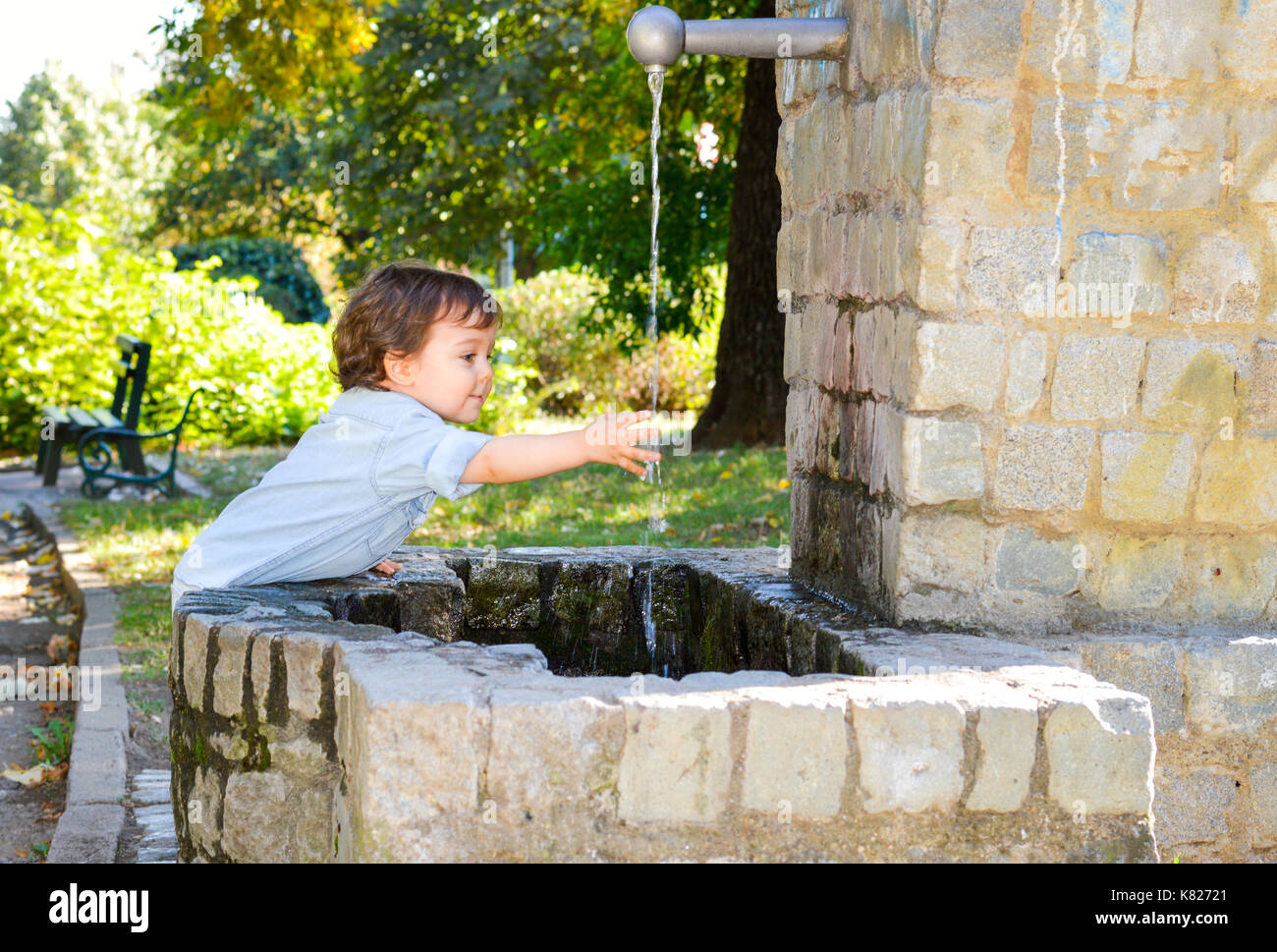 Happy boy washing hands in a park Stock Photo
