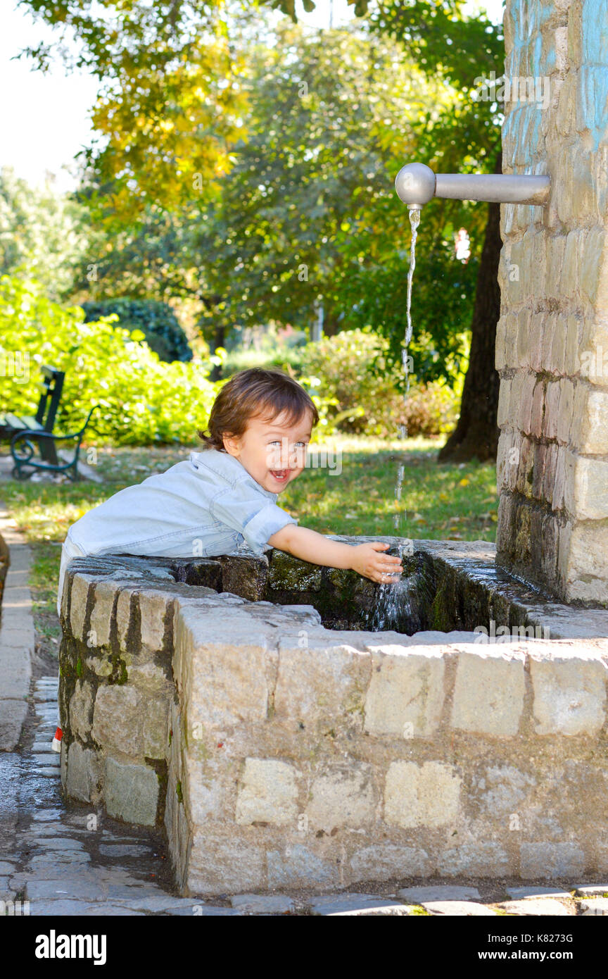 Happy boy washing hands in a park Stock Photo