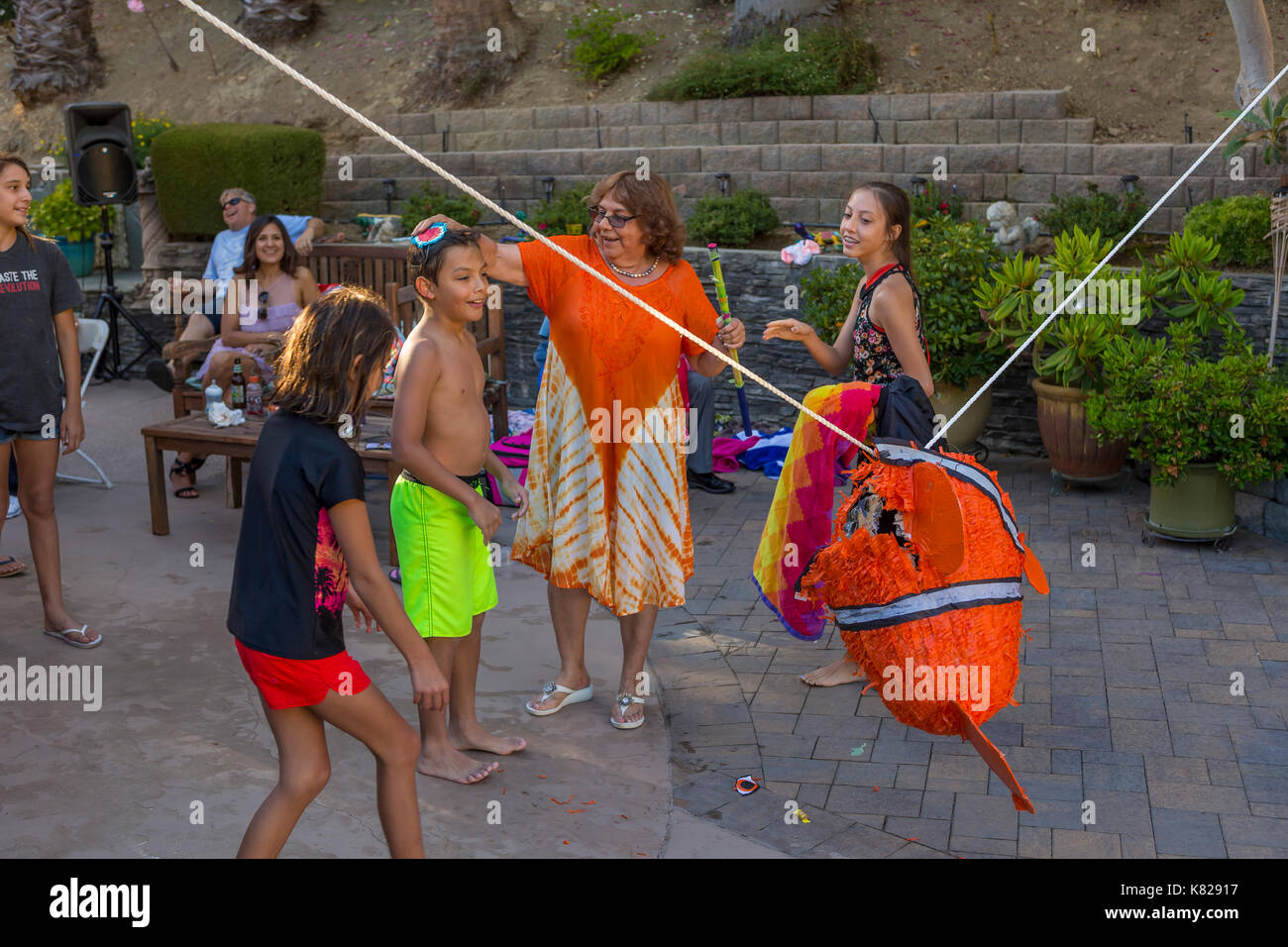 Hispanic boy, hitting a pinata, pinata filled with candy sweets