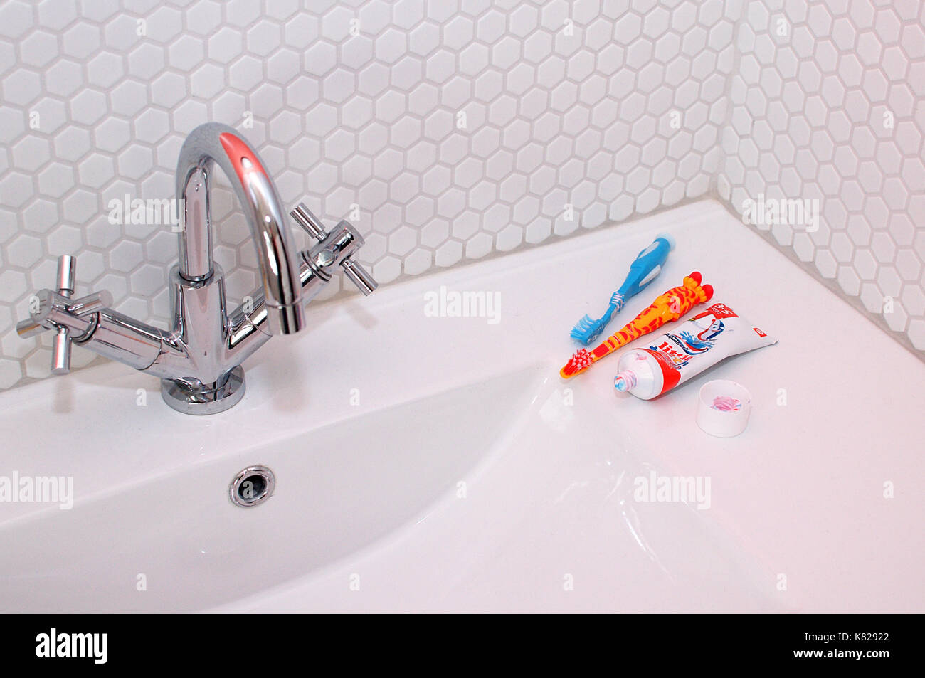 Toothpaste and toothbrushes on a sink in a bathroom Stock Photo Alamy