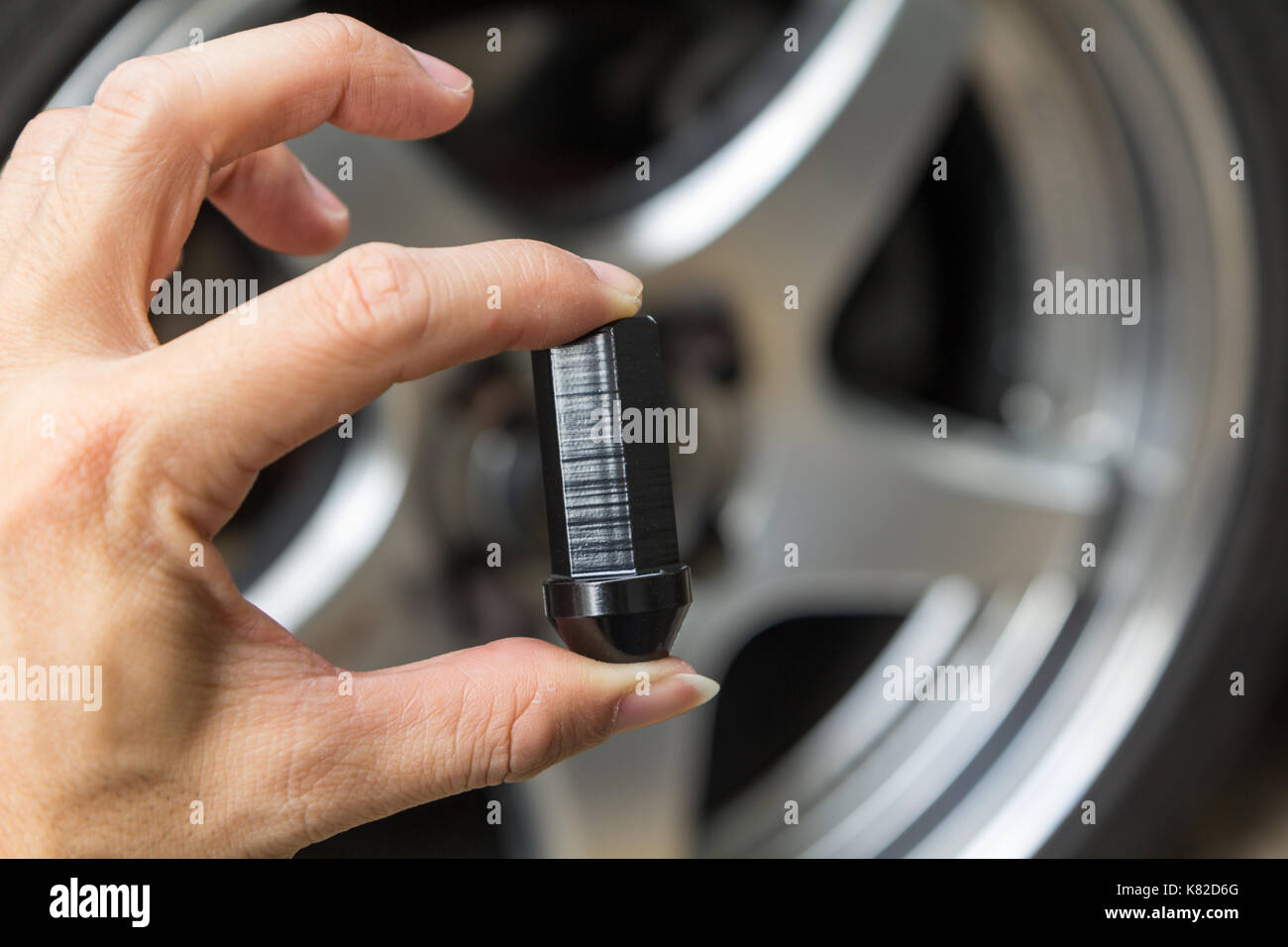 wheel nut of car in hand Stock Photo