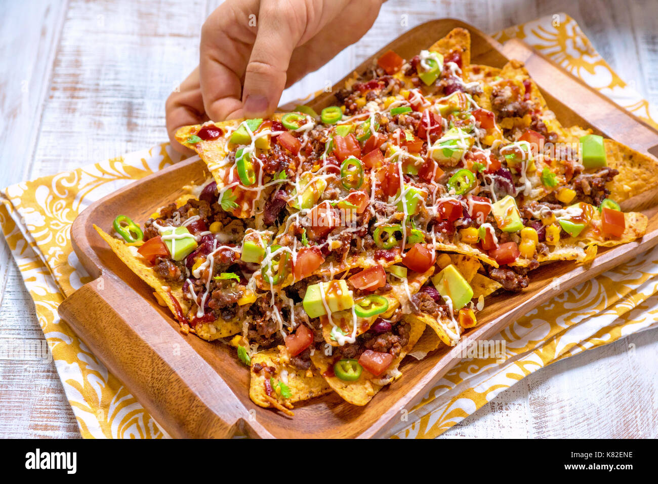 Mexican nacho yellow corn tortilla chips with cheese, meat, avocado