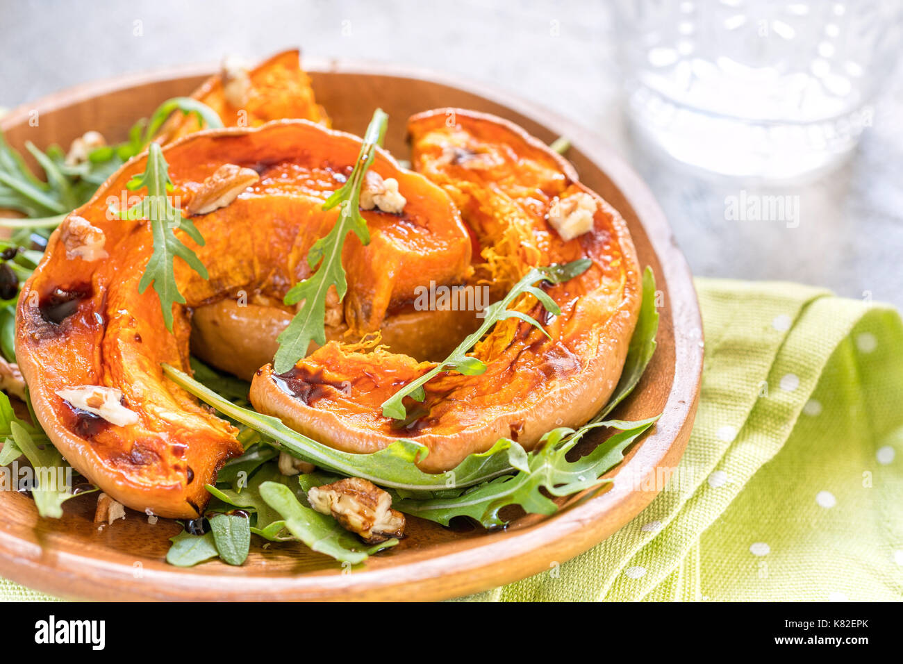 Roasted pumpkin with pecan nuts and arugula. Stock Photo