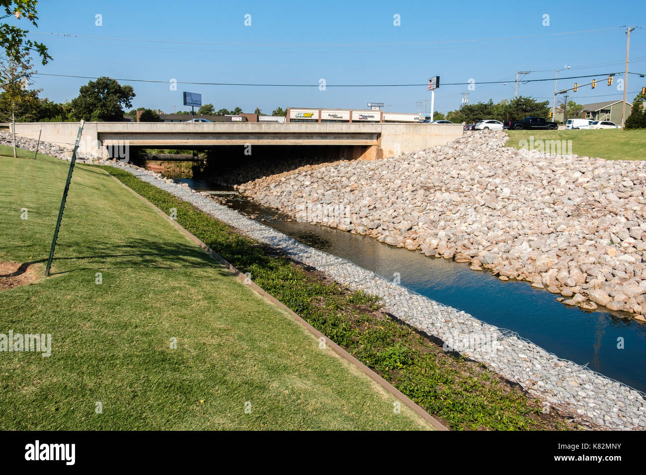 Rip-rap stones shoring up a drainage canal under a bridge in Oklahoma City, Oklahoma, USA. Stock Photo