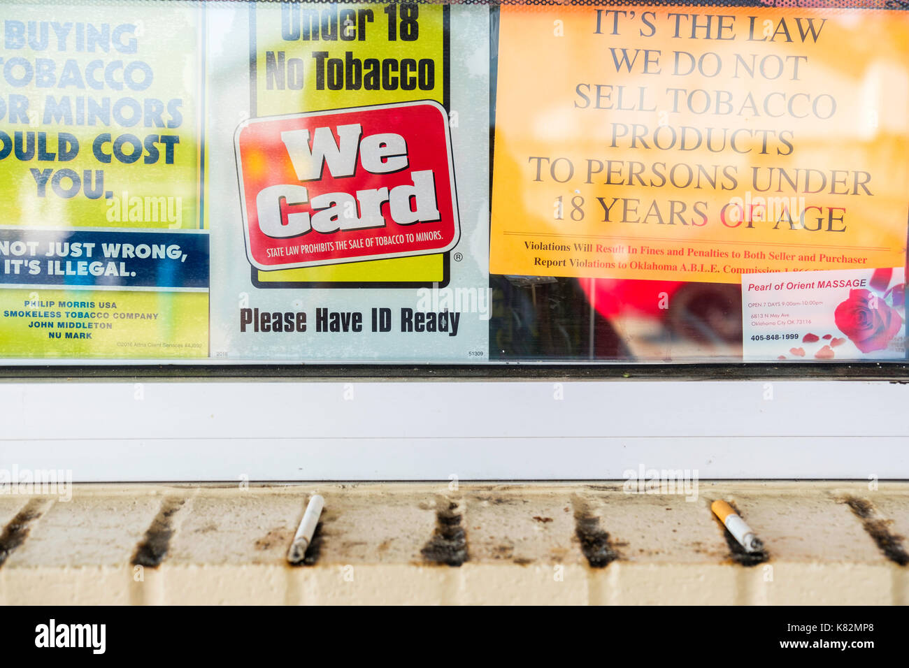 A gasoline station window displaying warning signs about minors buying  tobacco. Oklahoma City, Oklahoma, USA Stock Photo