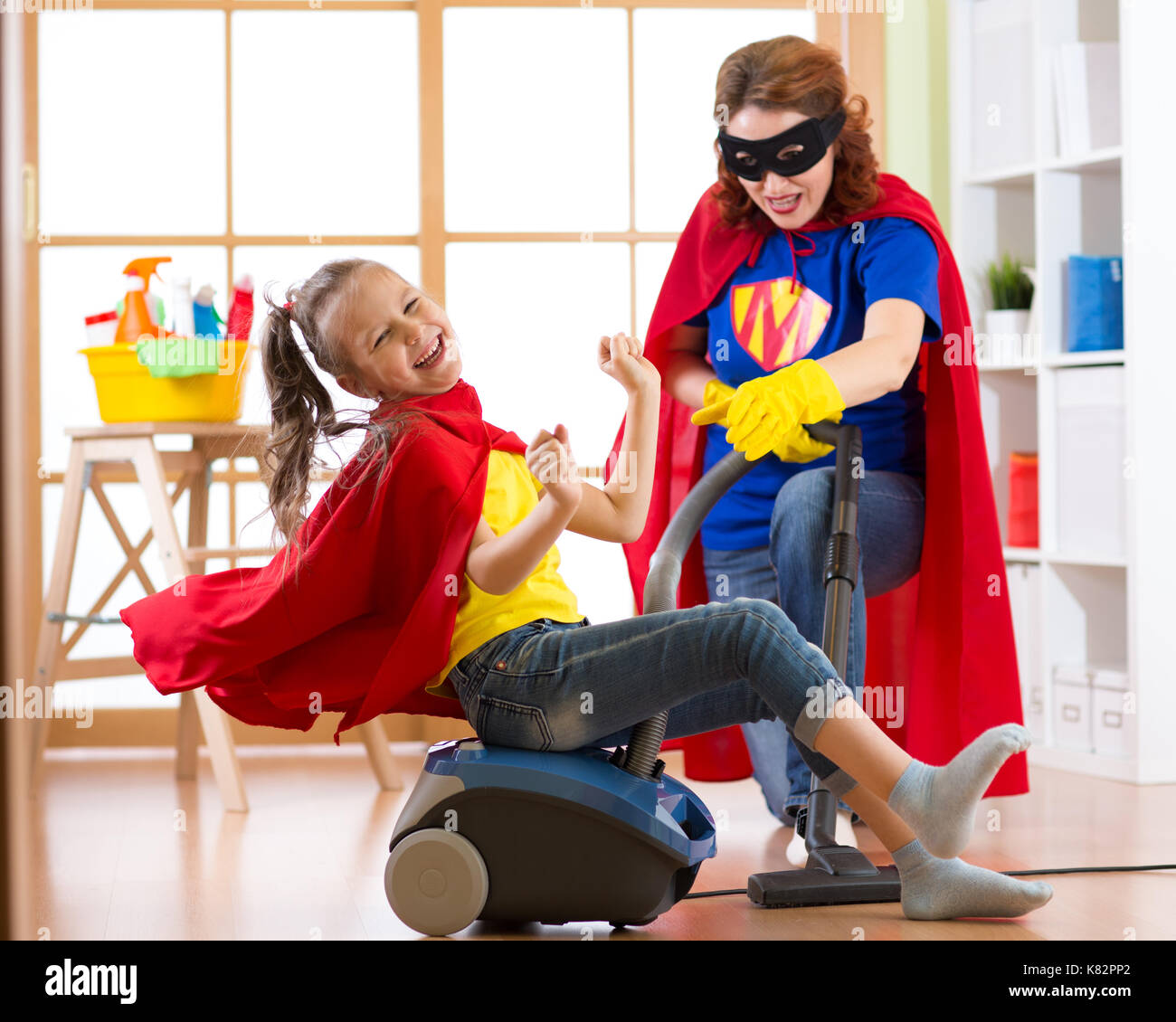 Child girl and her mother playing while doing cleanup at home Stock Photo