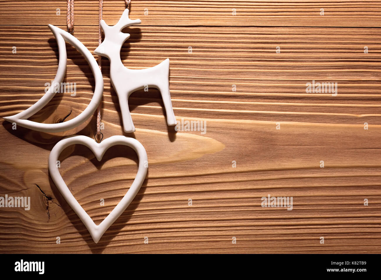 White Christmas decorations hanging on wooden wall. Background with space for text. Stock Photo