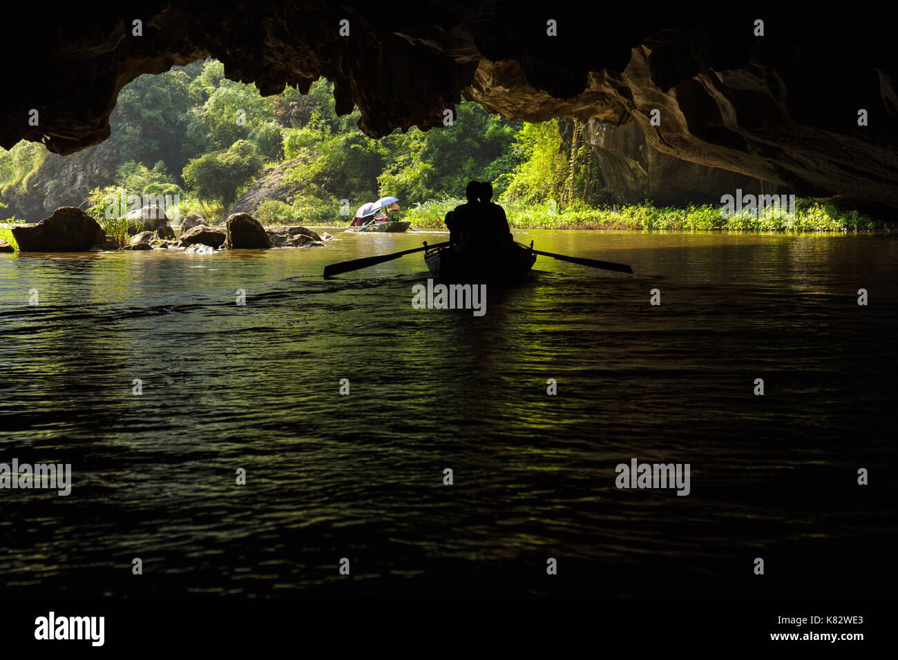 Two boats pass through a flooded cave on the Ngo Dong River, near Tam Coc village, at the Trang An UNESCO World Heritage site in Ninh Binh, Vietnam. Stock Photo