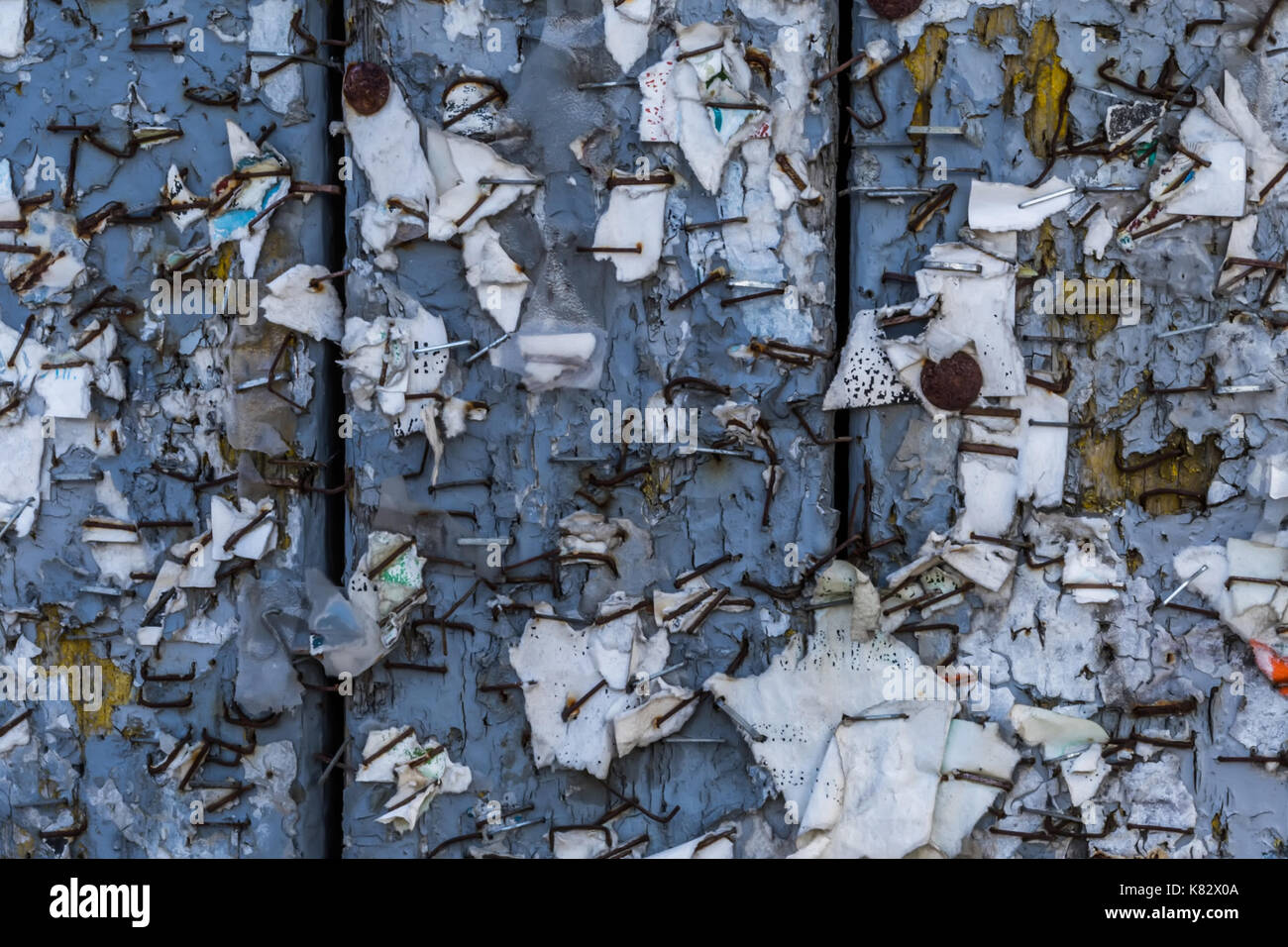 Old Urban Billboard With Torn Peeled Poster Abstract Horizontal Background. Outdoor Bulletin Board Or Plywood Panel With Worn Advertising Message Stock Photo