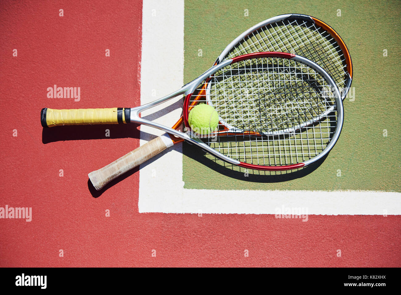 A tennis racket and new tennis ball on a freshly painted tennis court Stock Photo