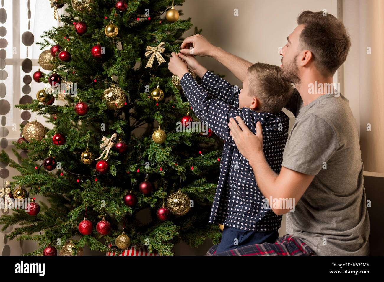 family decorating christmas tree together Stock Photo - Alamy