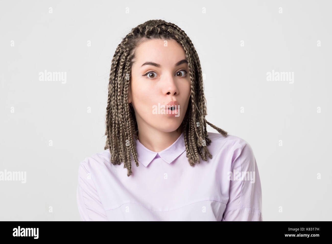 Surprised happy beautiful woman opening mouth in surprise. Her hair made in many african braids. Modern teen culture Stock Photo