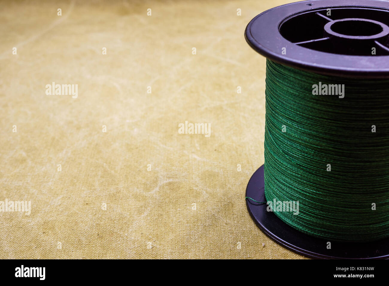 Spool of cord on the background of tarpaulin. Green fishing line