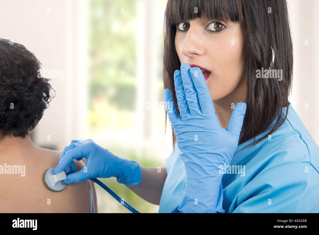 young female doctor examines a patient with a stethoscope Stock Photo ...