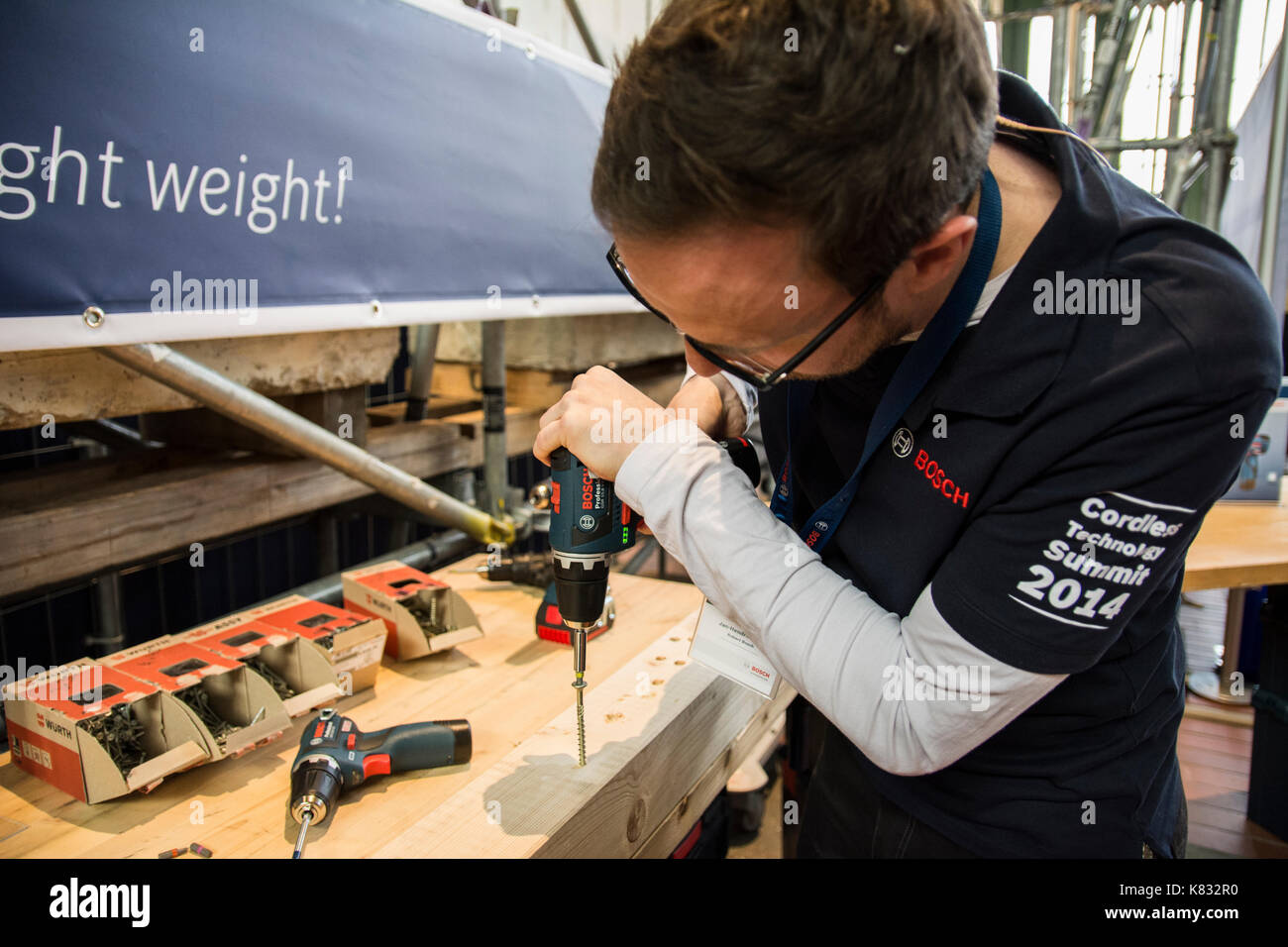 A man with glasses working in building with a Bosch cordless driller Stock  Photo - Alamy
