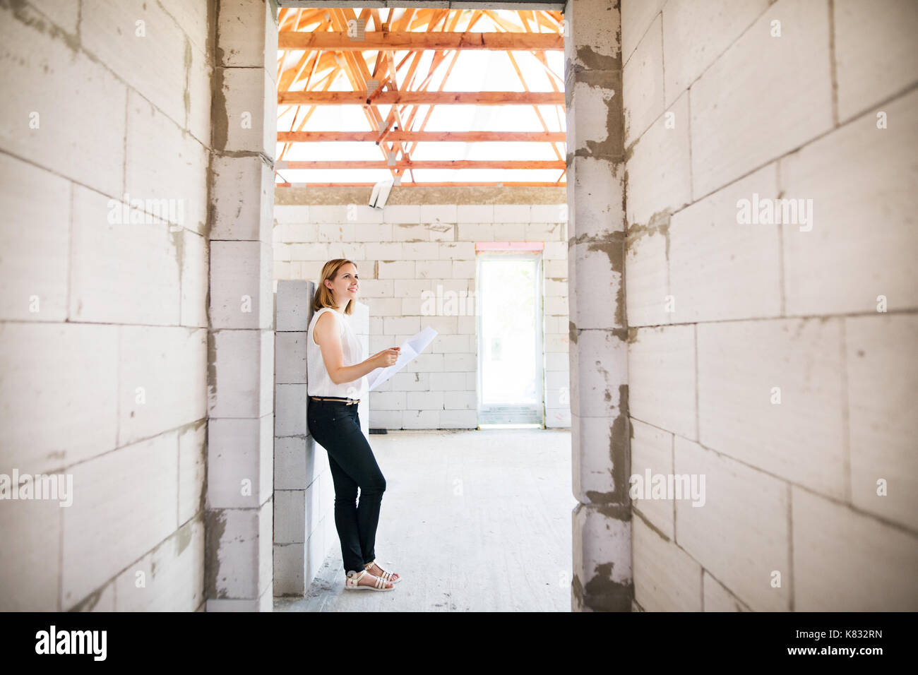 Architect at the construction site looking at blueprints. Stock Photo