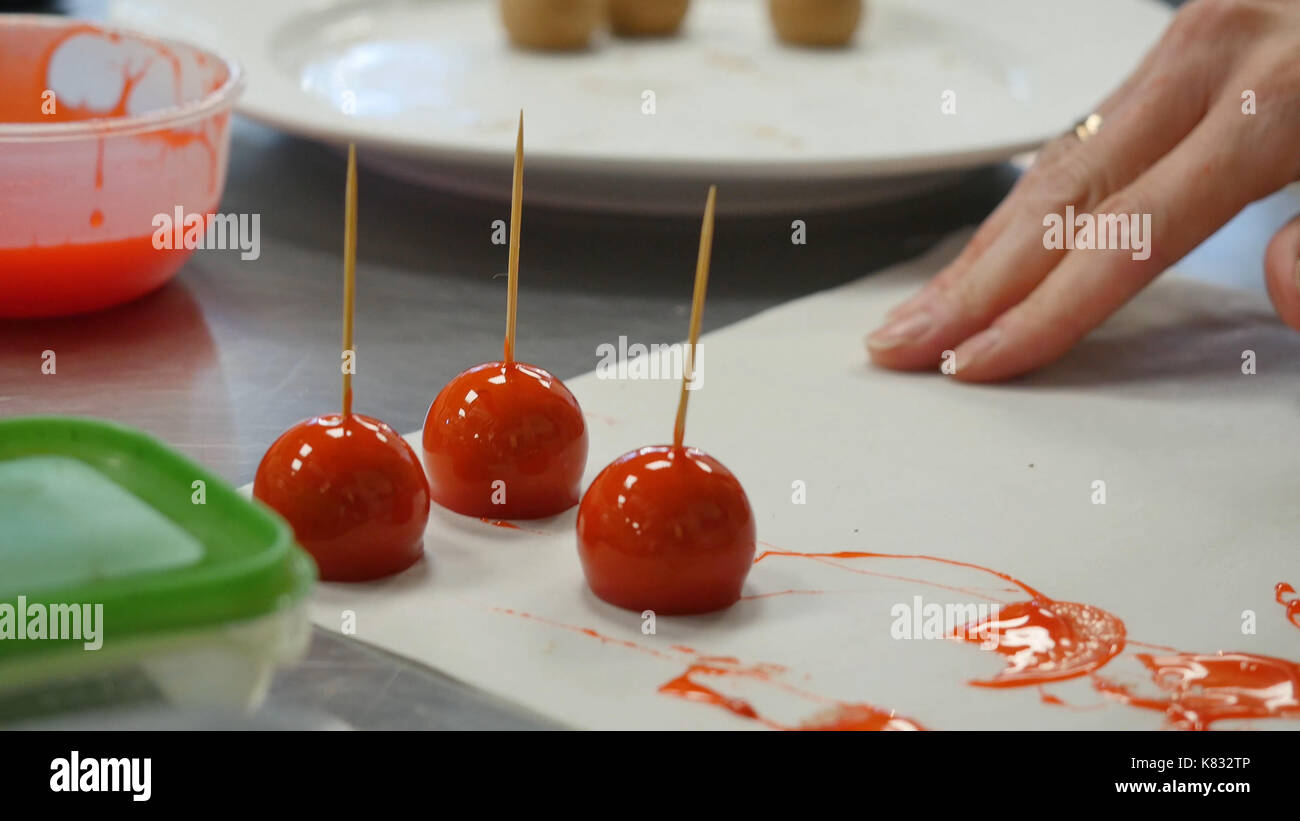 Woman dipping candy apple into bowl with caramel Stock Photo Alamy