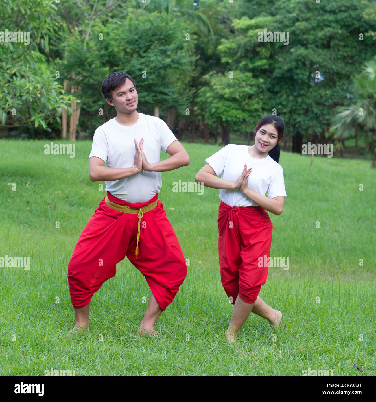 Asian young boy and girls learning Thai dance. Classical Dance in white shirt red loincloth, Demonstrate dance in the garden Stock Photo